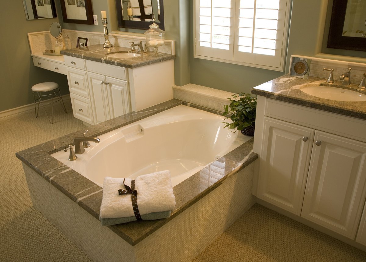 Licensed plumber inspecting existing bathroom plumbing before a remodel in an older Binghamton NY home