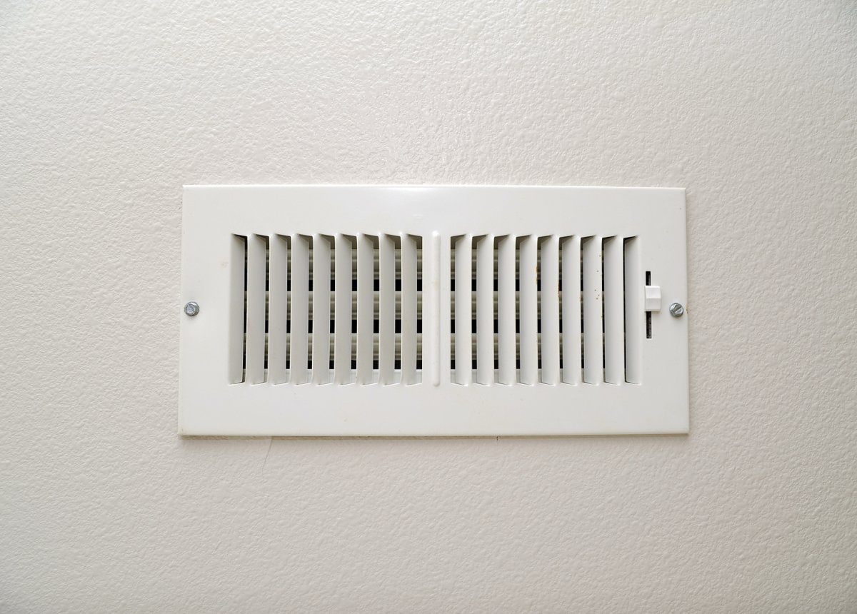 HVAC technician inspecting an air conditioner filter inside a Binghamton NY home during summer